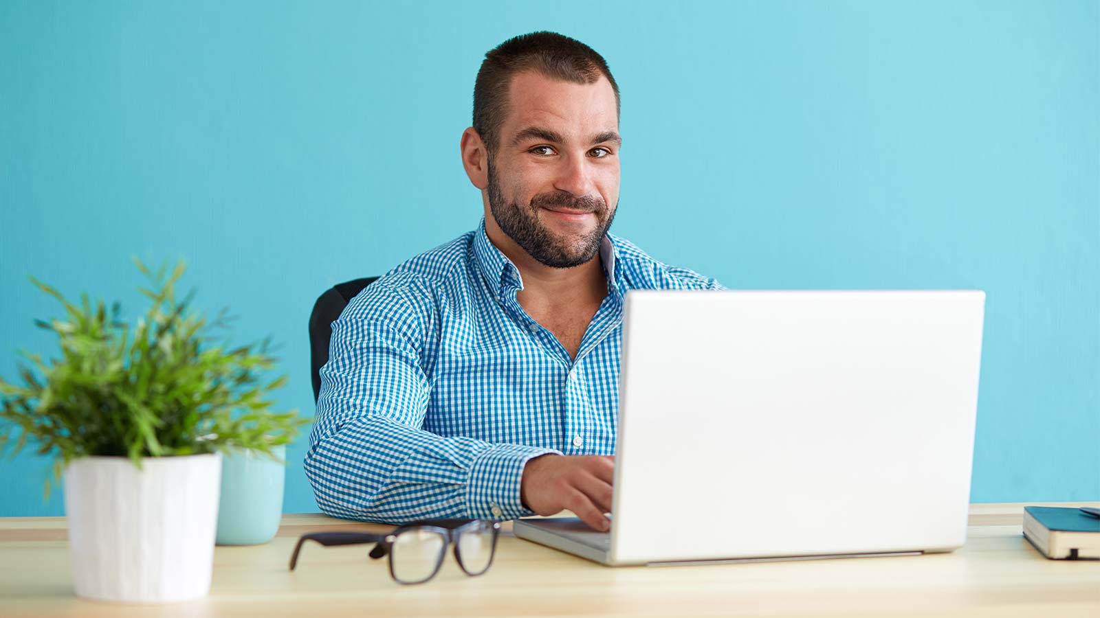 Musclebear with beard working on a computer